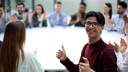 Group of young business workers clapping their hands. sitting and looking at the camera in the office.