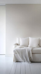 Cozy living room with a white sofa and soft blankets in a minimalist setting