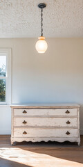 Vintage dresser in a bright minimalistic room with a hanging light fixture