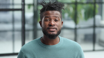 African American man in green sweater looking at camera