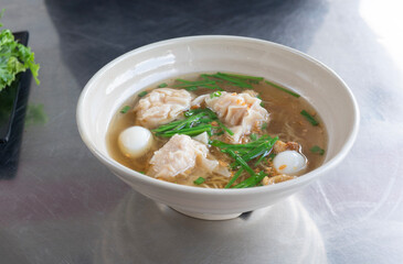 China noodle with pork wonton soup or pork dumplings soup with vegetable. Egg noodles with pork wonton soup or pork dumplings soup and vegetable.