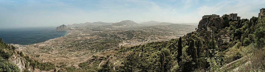 Panoramic view of the Sicilian landscape with mountains and coastline under a clear sky