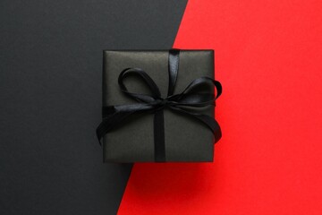 Beautiful gift box tied with bow on two tone background 