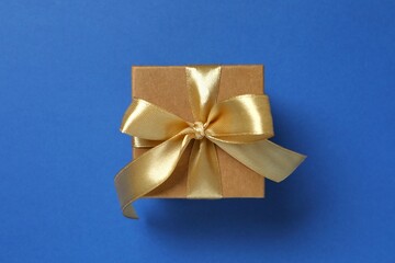 Beautiful gift box tied with bow on color background 