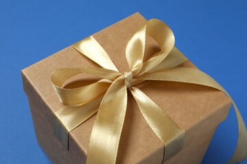 Beautiful gift box tied with bow on color background 