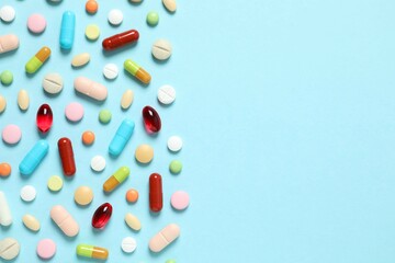 Various pills and capsules on a color background
