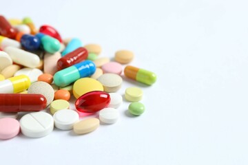 Various pills and capsules on a white background