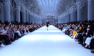 Fashion show featuring elegant designs in a stunning illuminated venue filled with spectators