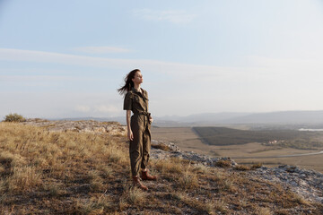 Obraz premium Woman standing on hill with majestic mountain view in background for travel and adventure inspiration concept