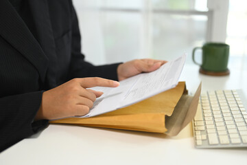 Close up of businesswoman analyzing important documents at desk