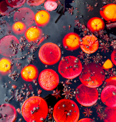 A close up of a bowl of fruit with a lot of oranges and red fruit