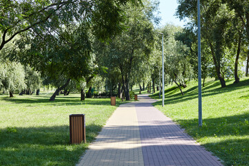 Walkway surrounded by trees and lawns in Kyiv, Europe. Recreation place in the city park