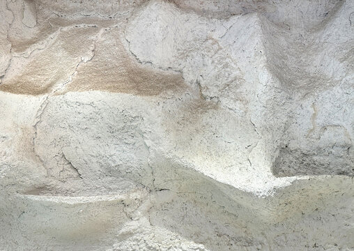 White natural stone cliff, sedimentary rock and rough cliff structure in white limestone color tone. Natural stone seamless background texture.