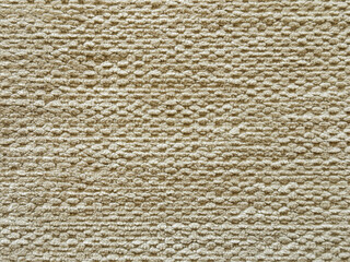 Close up texture of beige upholstery fabric, made of cotton and wool in a scaled square pattern. Light beige fabric suitable for clothing. Seamless background fabric texture.
