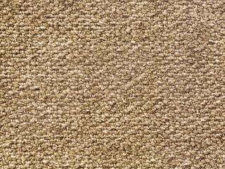 Close up texture of golden beige carpet fabric, made of cotton and polyester knitted and woven....