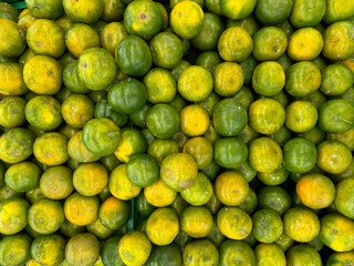 Photos of lime orange from top, on a basket. Good quality lime in beautiful shades of green and yellow color.