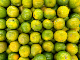 Photos of lime orange from top, on a basket. Good quality lime in beautiful shades of green and yellow color.