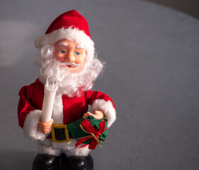 Christmas decoration in the form of Santa Claus with a gift and a candle.