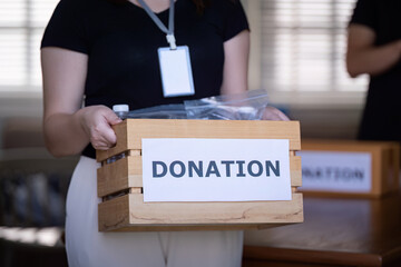 Volunteer Holding Box of Donations During Charity Drive