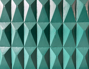 3D carved pyramidal and triangular 3D tiles in green tosca paint finish. 3D pyramid tiles for wall panel finishes, seamless background texture. 
