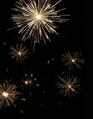 Naklejka premium New Year's sparkler or fireworks on a black background, Hand holding burning Sparkler blast on a black bokeh background at night,holiday celebration event party,dark vintage tone