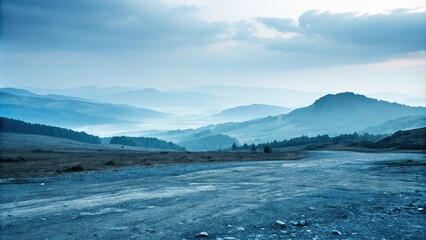 Misty blue landscape with rugged terrain, moody tone, rocky outcroppings