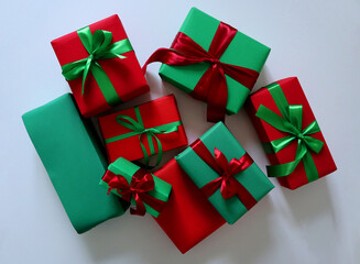 Set of gifts on white background. Traditional Christmas red and green colors. Boxes of different sizes. Tied with ribbons and bows. Red boxes have green ribbons and bows, green with red ribbons. Photo