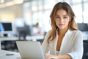 Professional businesswoman working at modern office desk with laptop focused expression in corporate setting