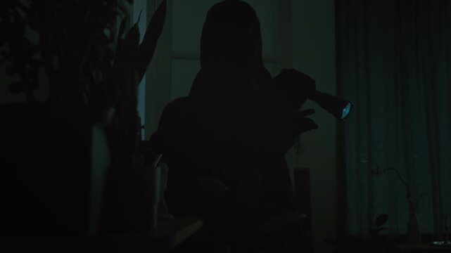 Two male criminals in total black with flashlight and metal crowbar entering apartment and glancing around