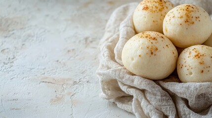 Crispy Brazilian pão de queijo rests on a cloth, showcasing its delightful texture
