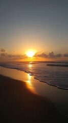 Obraz premium Golden Sunrise Over Ocean Beach Sands