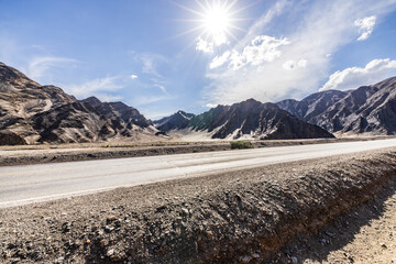 Asphalt highway road and mountain nature landscape under blue sky. Road trip.