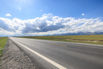 Countryside asphalt road and green grassland nature landscape in Xinjiang. Road trip.