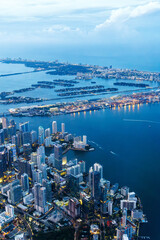 Fototapeta premium Aerial view of Miami skyline with skyscrapers at Downtown Brickell and Miami Beach at night portrait format in Miami, United States