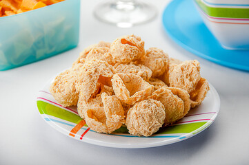 Dried soy meat chunks on a colorful plate with snacks in the background