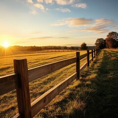 Obraz premium Serene Sunset Over Lush Pastureland with Wooden Fence Along the Horizon, Soft Clouds and Golden Light Painting the Tranquil Countryside Landscape