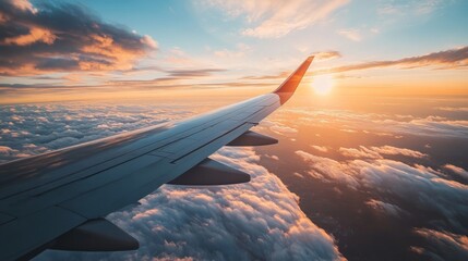 Airplane wing view during a vibrant sunset above fluffy clouds.