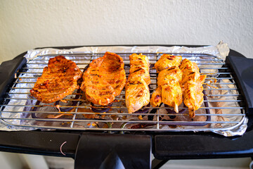 The meat is cooked on an electric grill