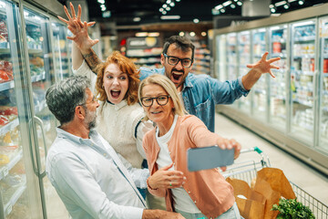 Cheerful family taking a selfie while grocery shopping in supermarket