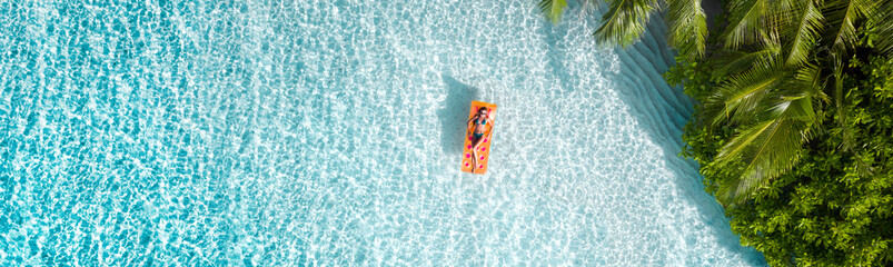 Top above high angle aerial drone view of fit slim attractive girl floating on rubber mattress sea water luxury leisure sunny weather relax enjoying season mild warm pleasant climate wild forest © deagreez