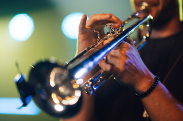 Musician playing trumpet on stage during concert