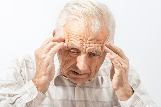 Mature man clutching his head with his hands. Older man suffers from headache, forgetfulness, memory problems.