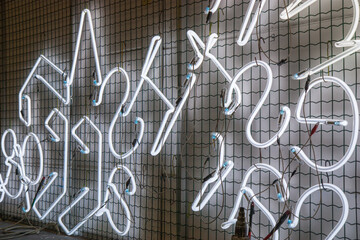 Newly made neon tubes in shape for new neon signage. neon hangs on a window to burn in at the right...