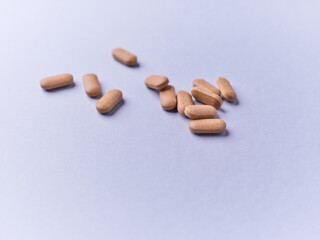 Ashwagandha (Withania somnifera) tablets on paper background. Soft focus. Close up. Copy space.	