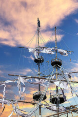 Torn sails on the masts of a pirate ship against the sky
