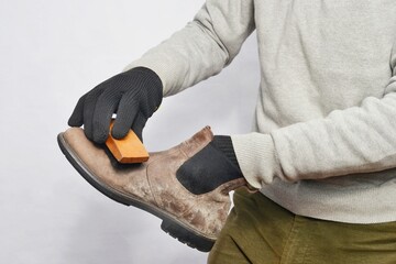 Cleaning dirty old boots with a brush ,male hands.