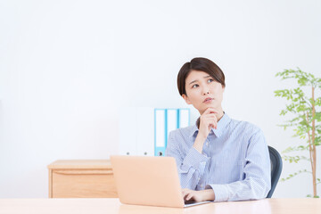 パソコンで仕事する考える女性