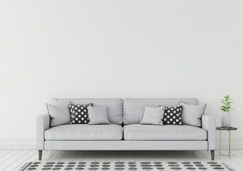 A modern grey sofa with black and white patterned pillows sits on a patterned rug in a minimalist living room with white walls and wooden floors