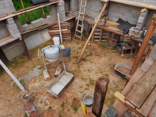 A construction site with a cement mixer inside. Scene is that of a work in progress, with the...