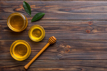 Honey jar with wooden honey dipper on white background top view with copy space. Delicious honey bottle